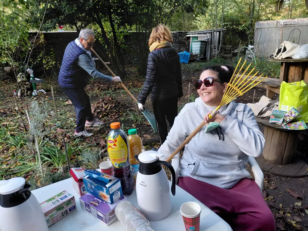 Bénévoles ratissant et préparant le goûter au jardin