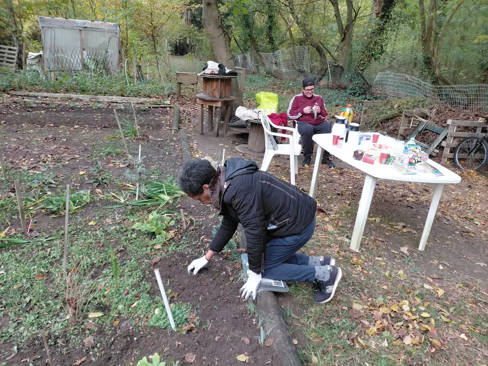 Bénévole plantant tandis qu’une autre prépare le goûter