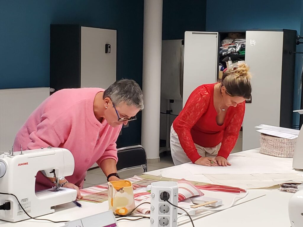 Deux participantes traçant un patron sur la table de coupe